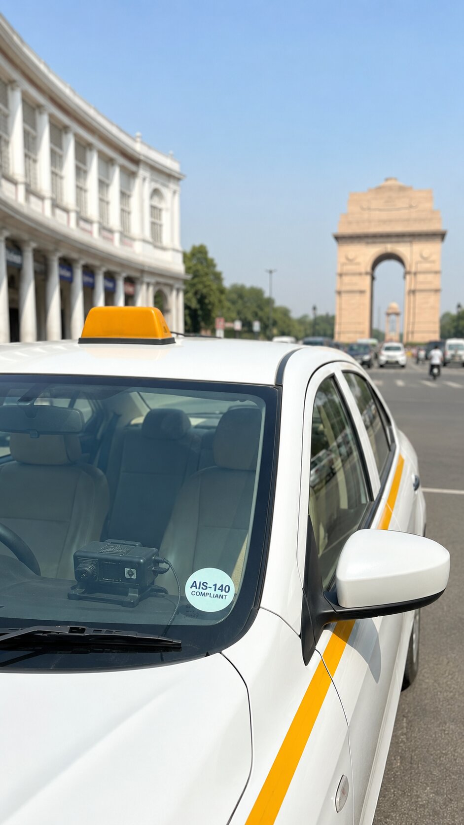 White sedan taxi on a Delhi road with a GPS device visible through the windshield and India Gate or Connaught Place in the background.